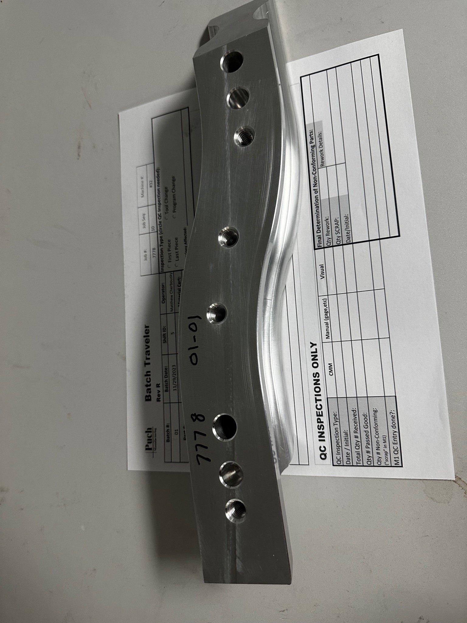 Machined marine component on production traveler paperwork ready for inspection